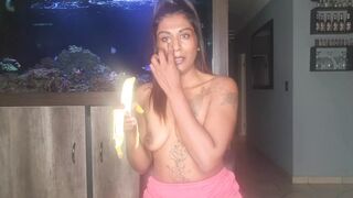 Topless desi squeezes her boobs as she sucks and deepthroats on a banana - 1 image