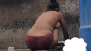 Desi Indian village bathroom in open courtyard wearing red tights bathing - 1 image